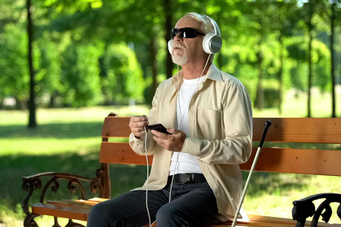 old blind man with headphones